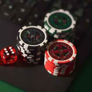Spelmarker och tärning vid dator där man spelar casino online